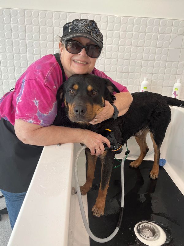 woman hugging dog in tub