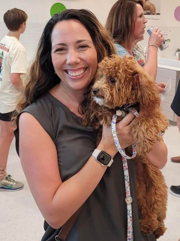 woman smiling holding puppy